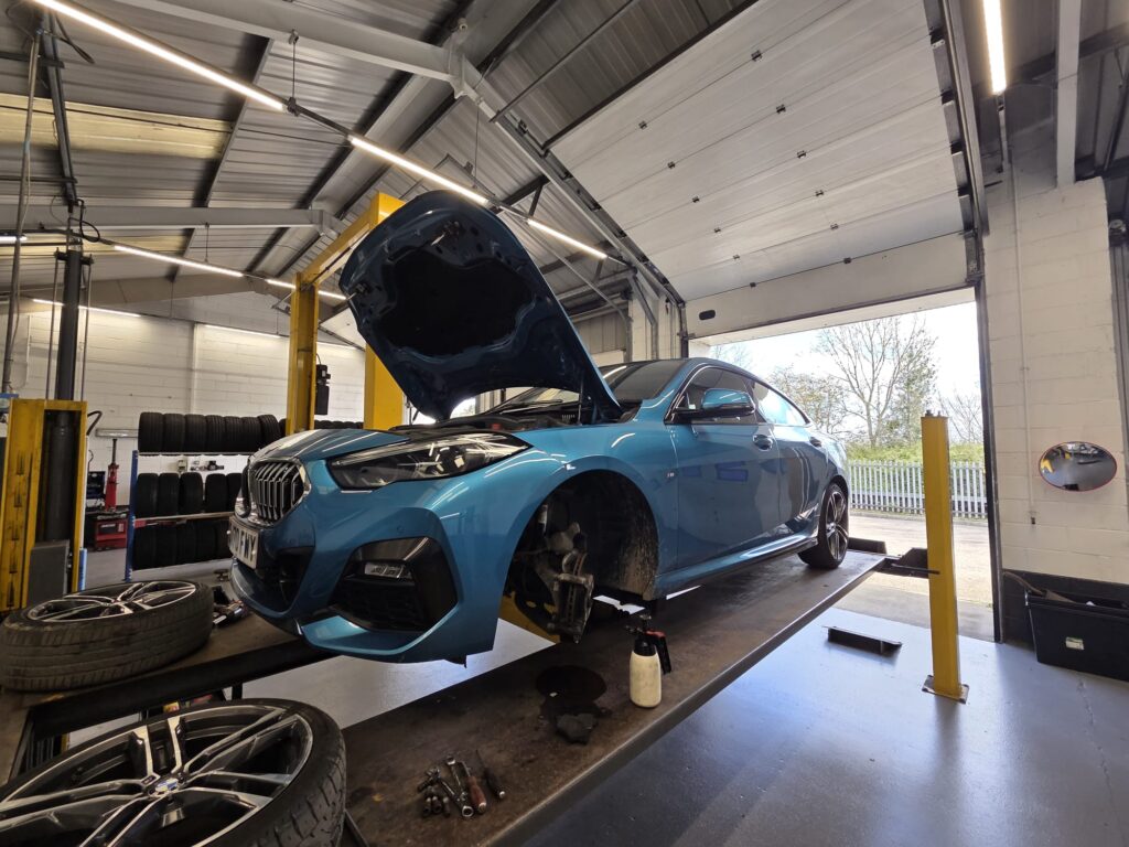 Car on ramp with bonnet open during MOT inspection and repairs at Apex MOT & Autocare York
